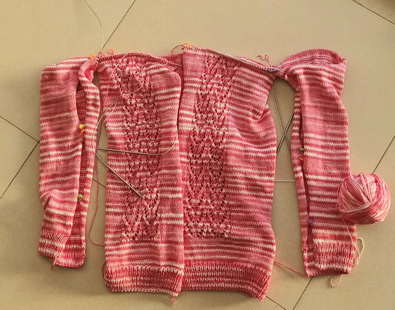 Вот так выглядит процесс ввязывания рукавов: отовсюду торчат вспомогательные спицы и маркеры для убавления петель.